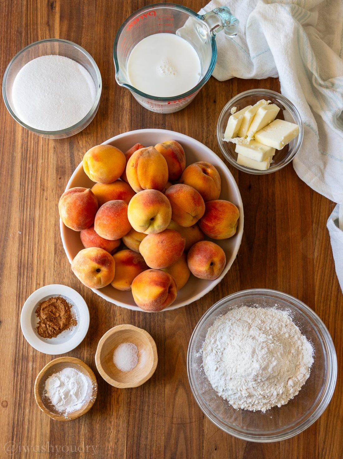 ingredients for old fashioned peach cobbler recipe on wooden surface.