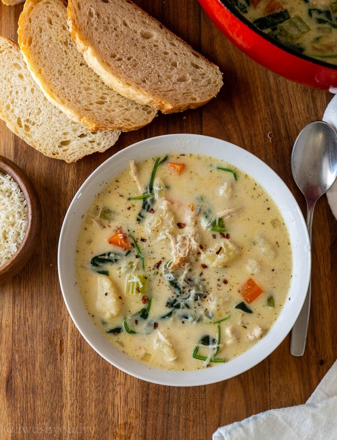 bowl of chicken gnocchi soup with spoon beside it.