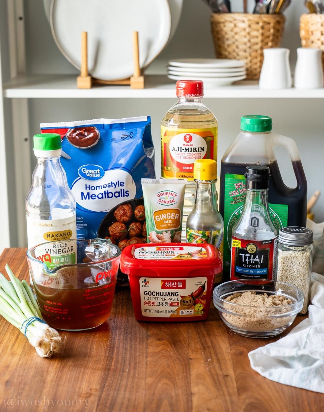 ingredients for korean bbq meatballs with sauce on a wooden surface.
