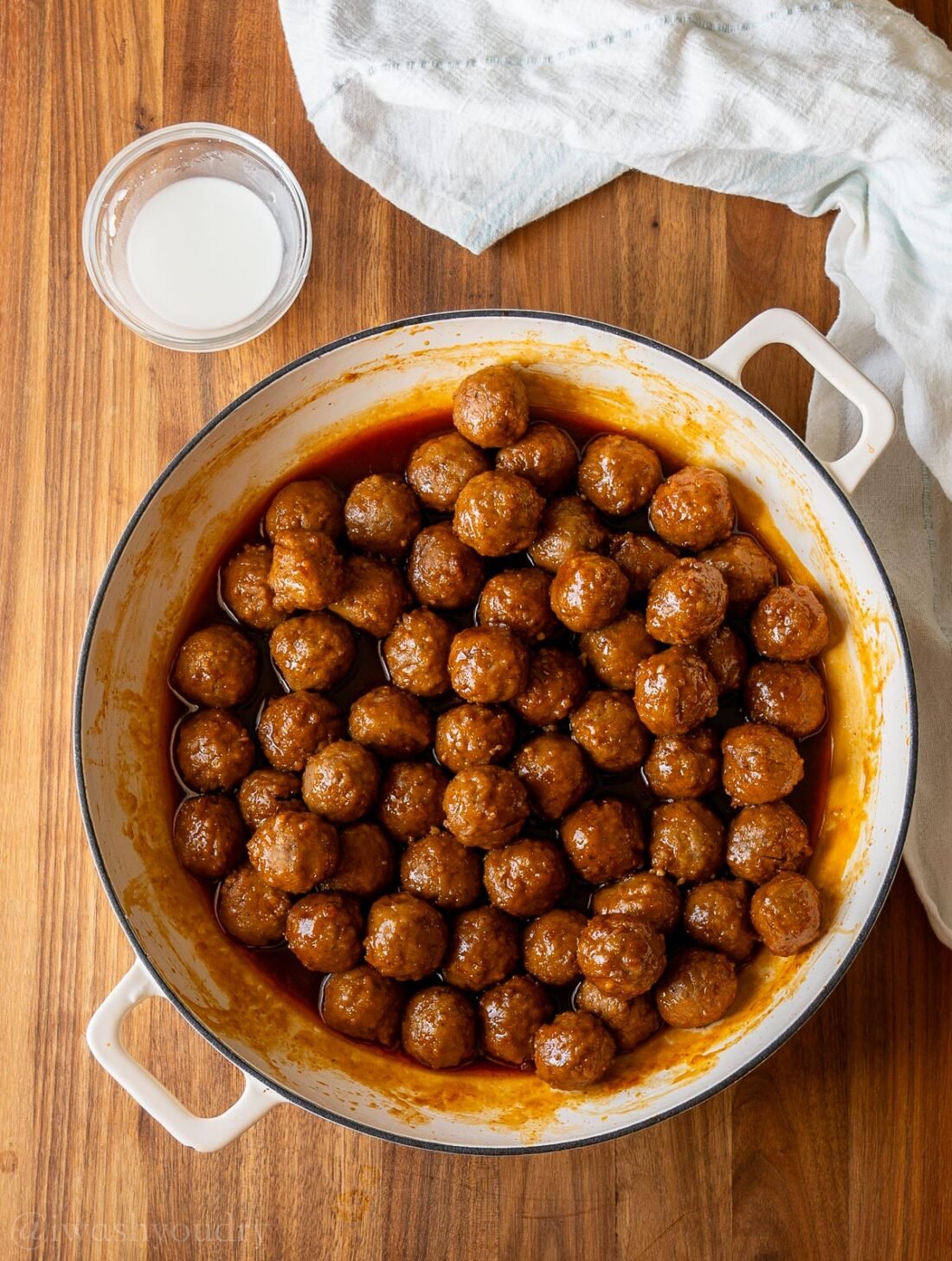 meatballs in sauce with cornstarch slurry next to it.