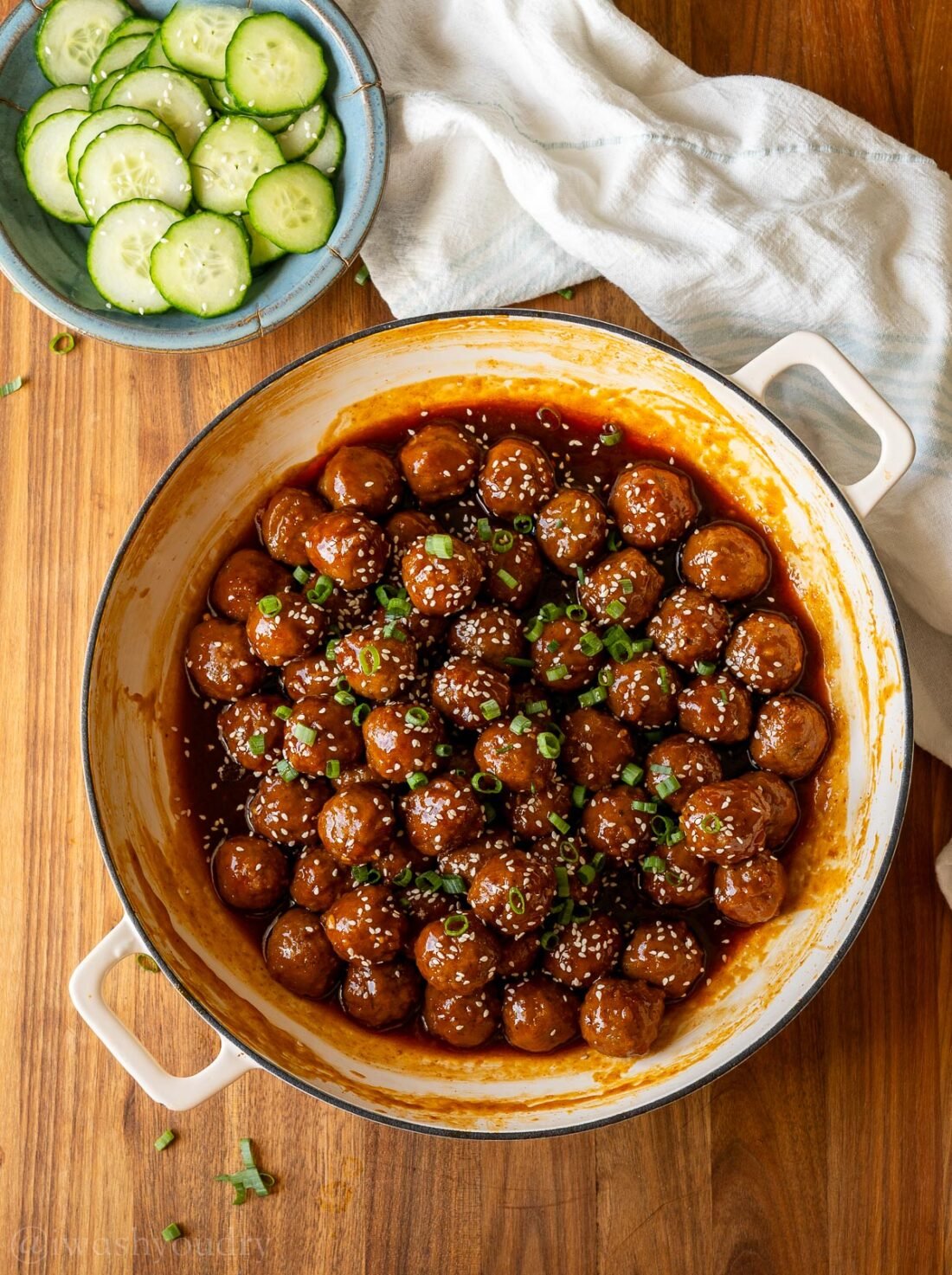 pan with meatballs and bowl of cucumbers near by