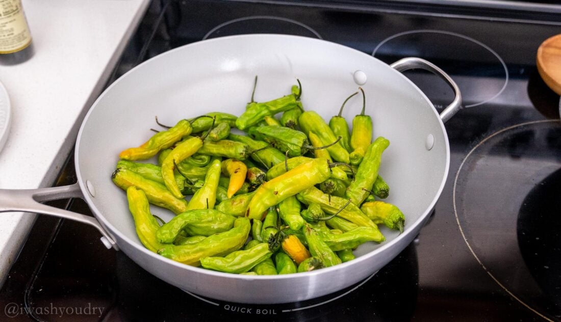 cooking peppers in large wok on stove top.