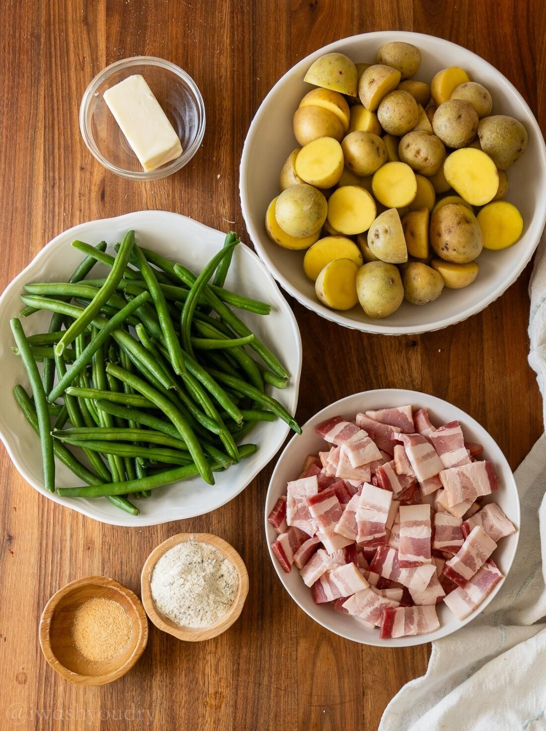 ingredients for potatoes and green beans with bacon and ranch seasoning on wooden surface.