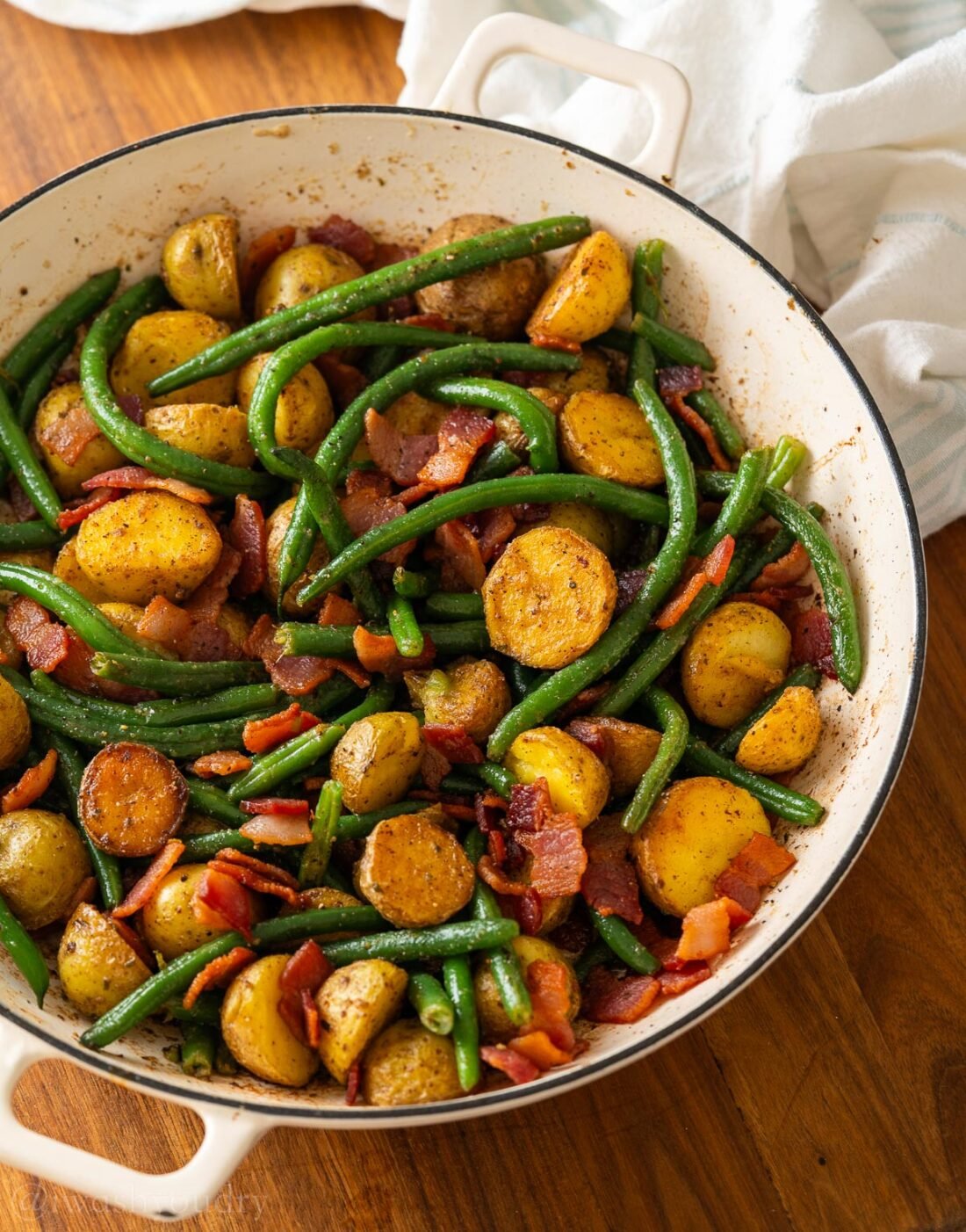country potatoes and green beans with ranch seasoning in a white dish.