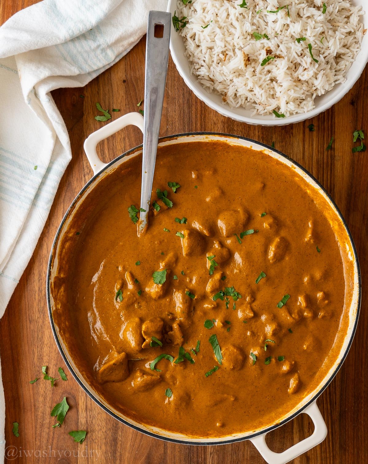 sauce pan full of chicken coconut korma, topped with cilantro.