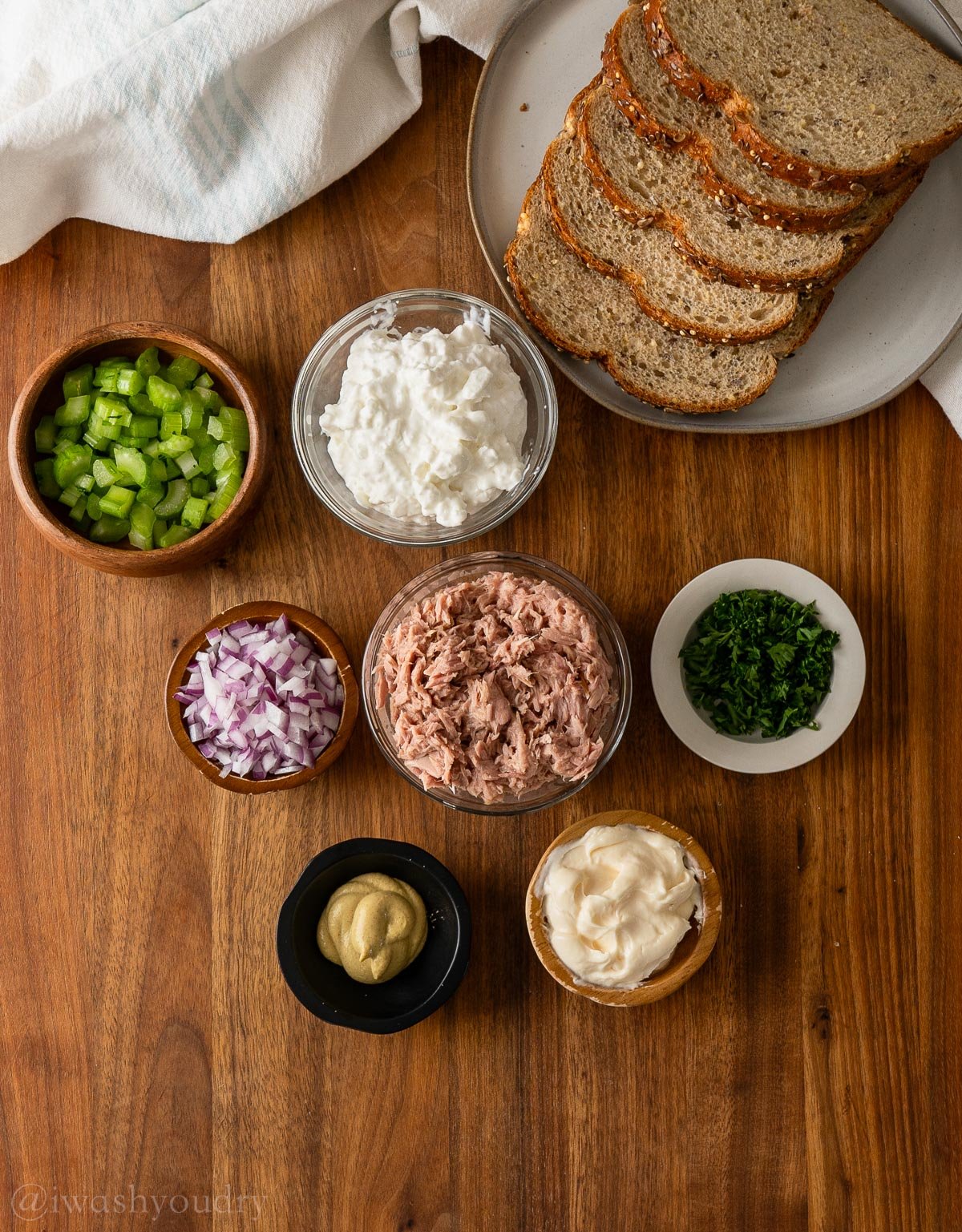 Ingredients for Tuna salad on wooden surface with celery and mayo.