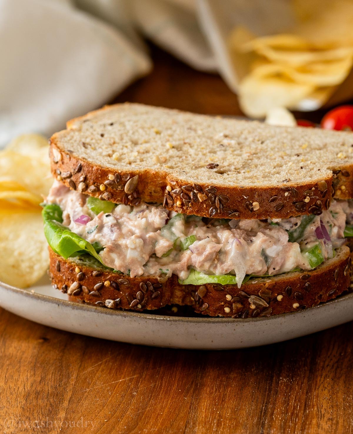 tuna sandwich on wheat bread with lettuce.