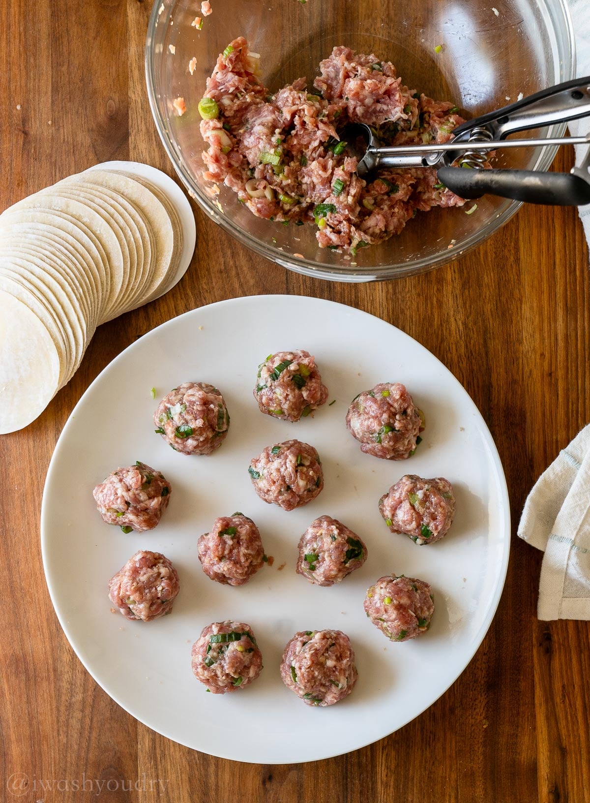 meatballs on plate with cookie scoop in bowl nearby.