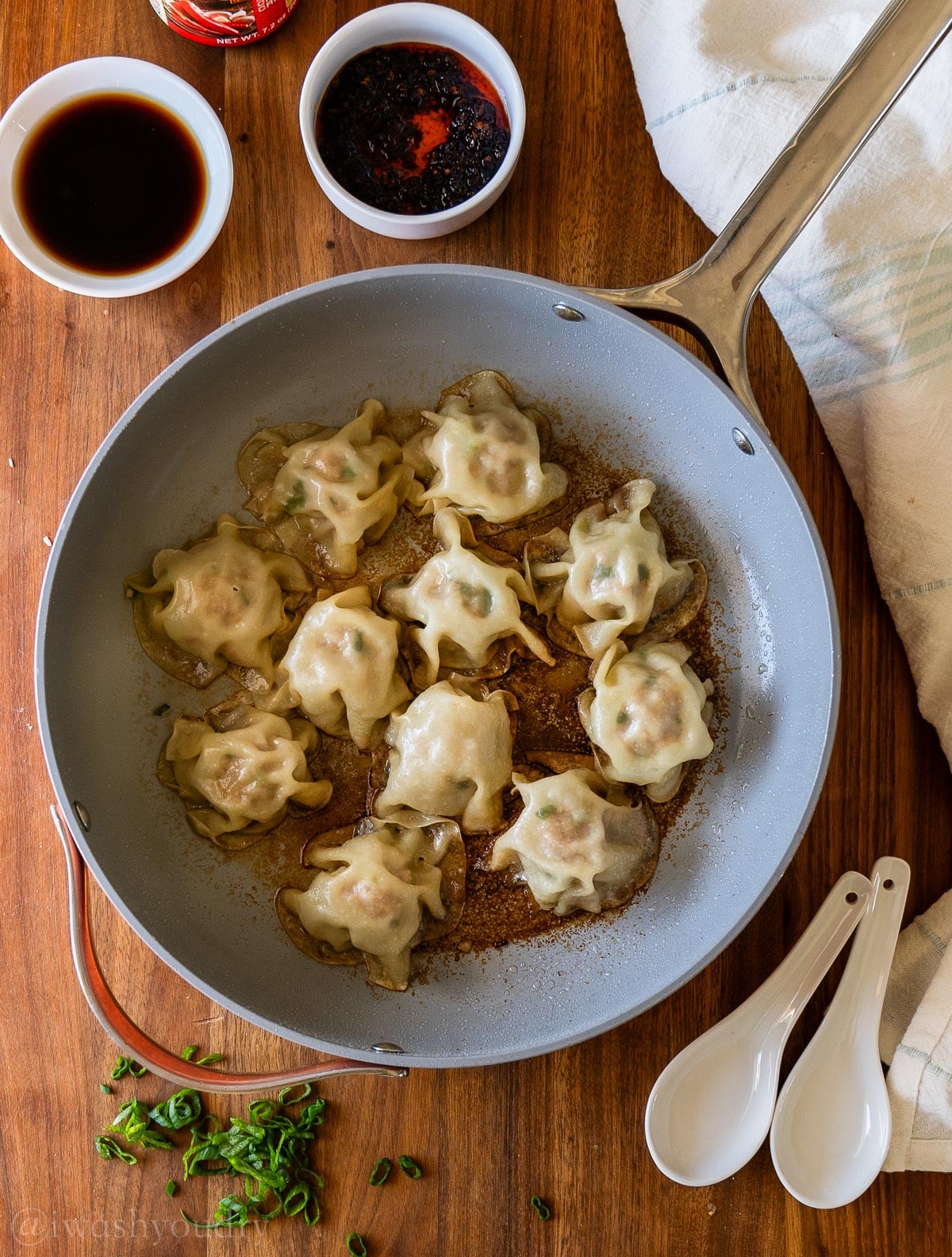 steamed and cooked dumplings in skillet.