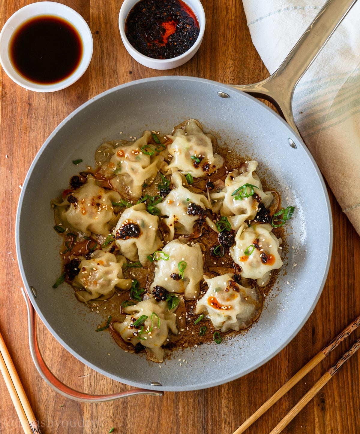 Blanket dumplings in a skillet with green onions and pork.