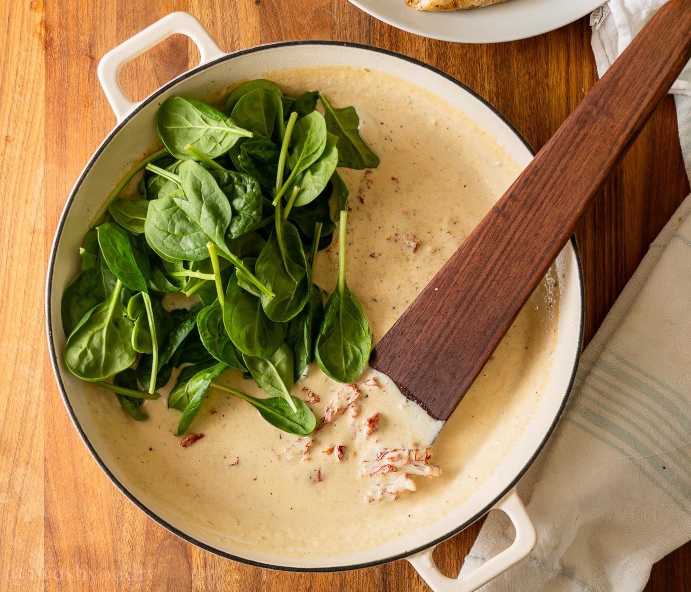 creamy sauce with wooden spoon in it. 