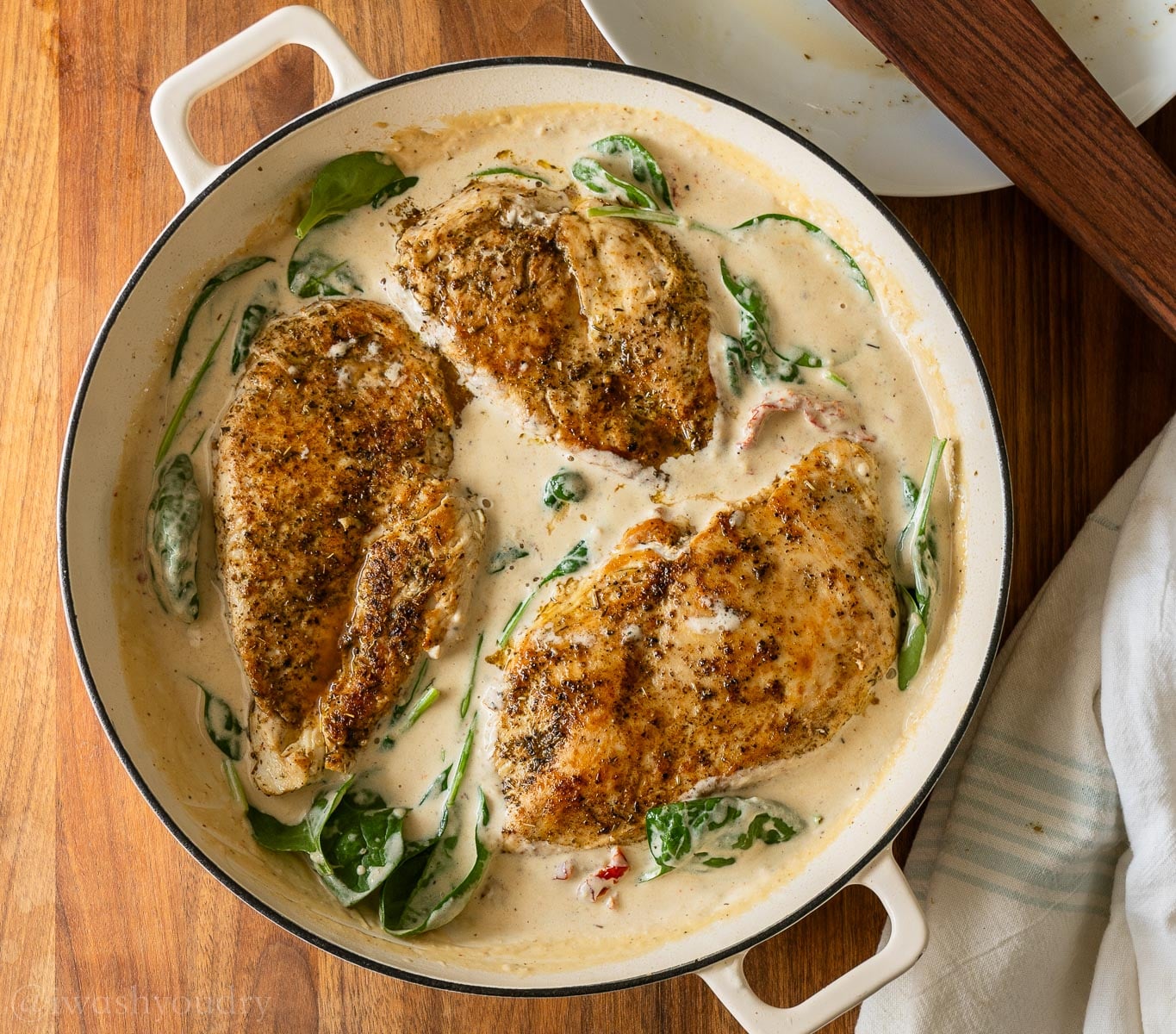 cooked chicken breast in creamy tuscan sauce with spinach.