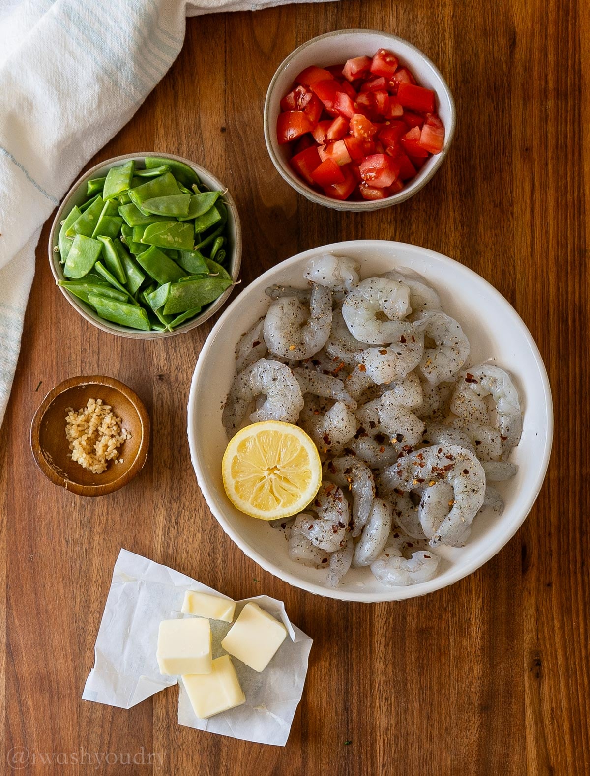 shrimp and ingredients for pasta on wooden surface - with butter and lemons.