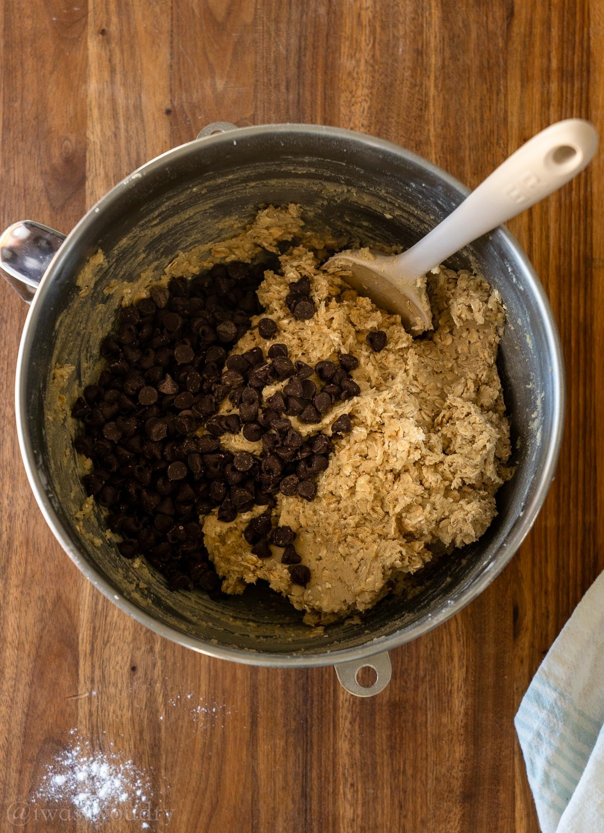 oatmeal chocolate chip cookie dough in mixing bowl with extra chocolate chips.