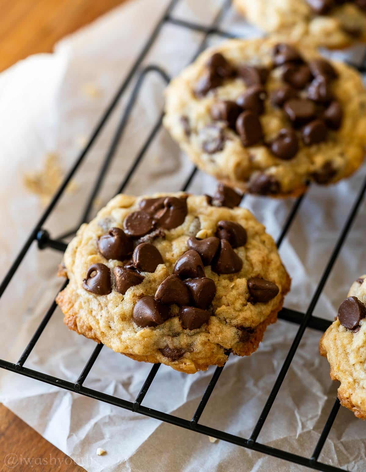 Chocolate chip cookies with oats on a cookie rack.